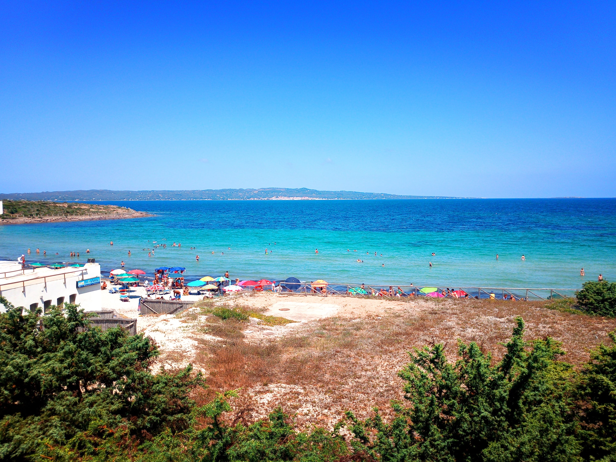 Spiaggia affollata con ombrelloni sul mare azzurro