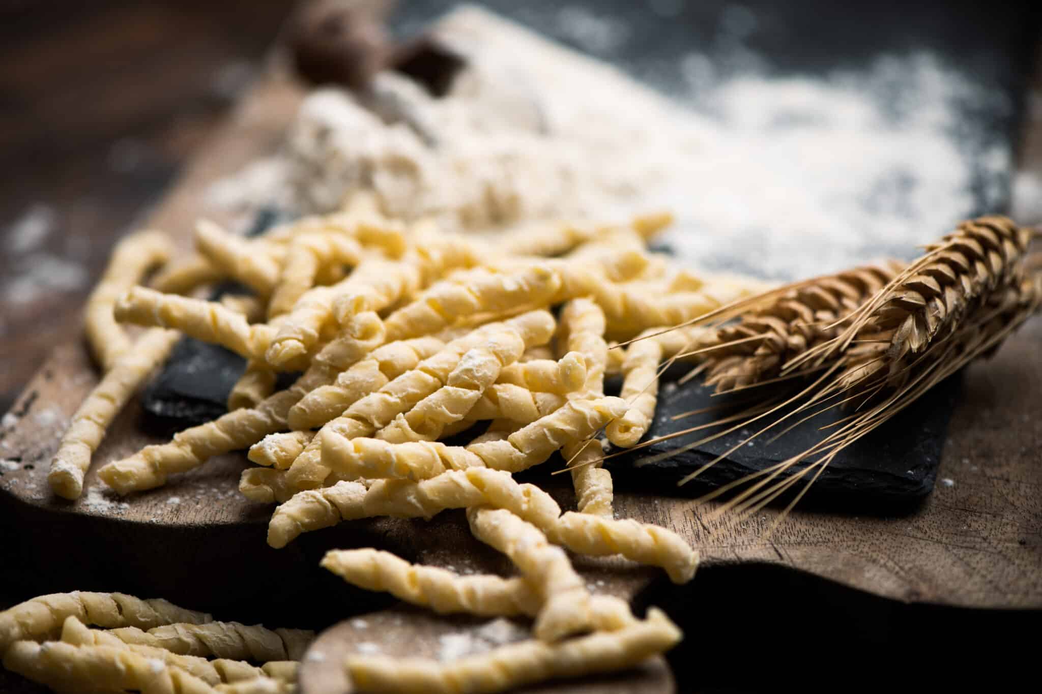 Gnocchi crudi su tavola di legno con spiga