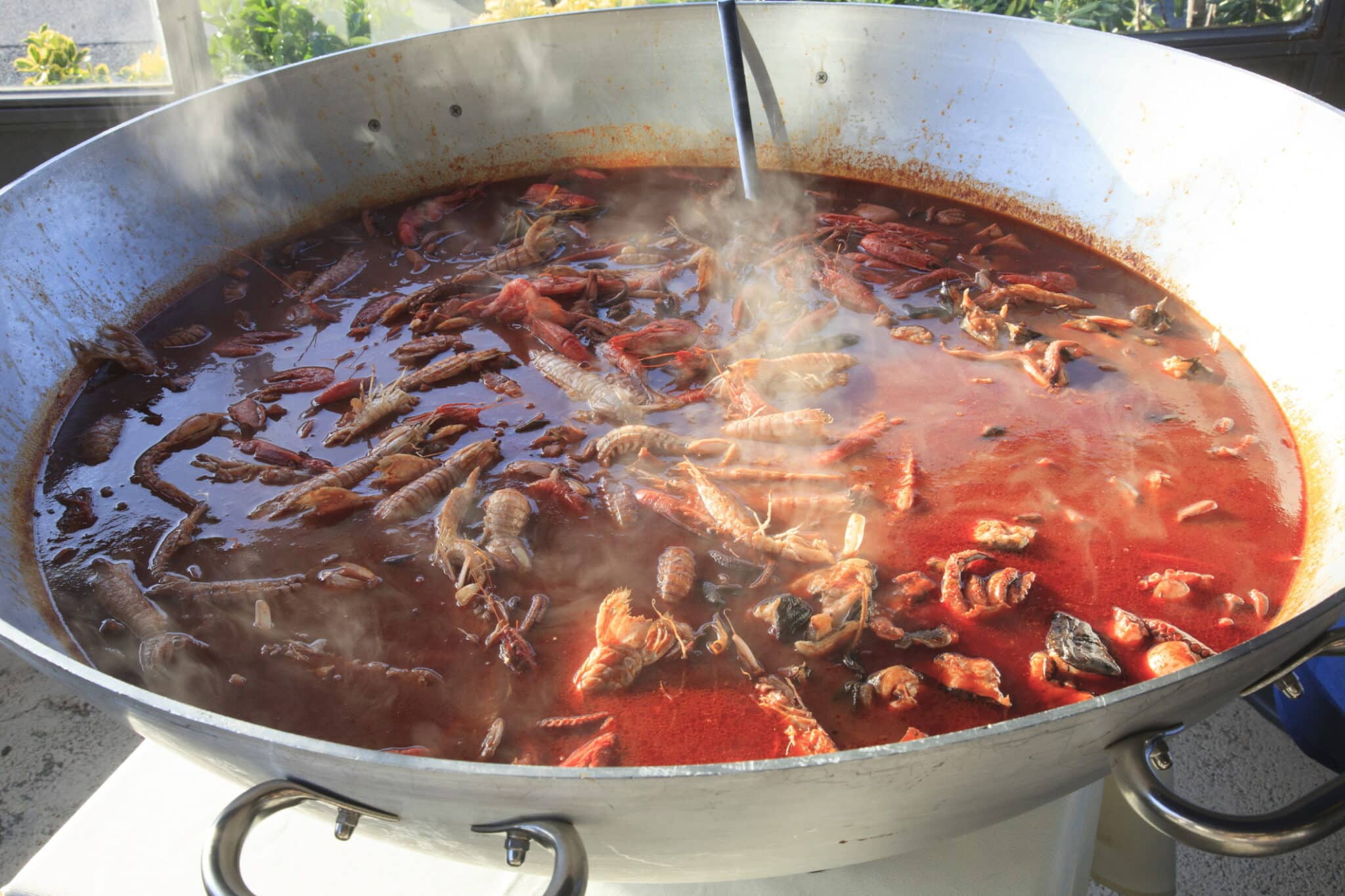 Grande pentola con brodo e crostacei in cottura