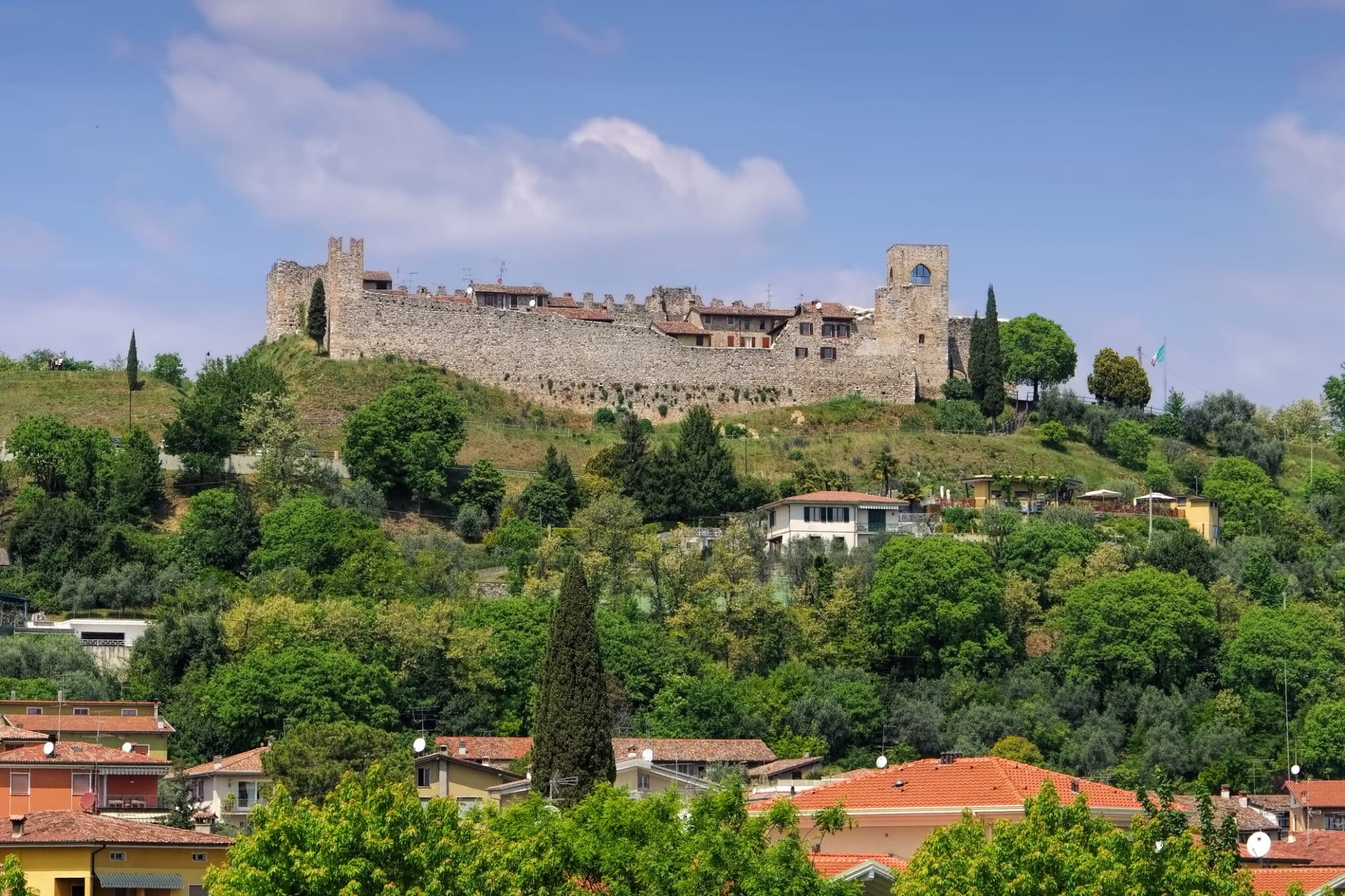 Antico castello su collina verde sotto cielo azzurro