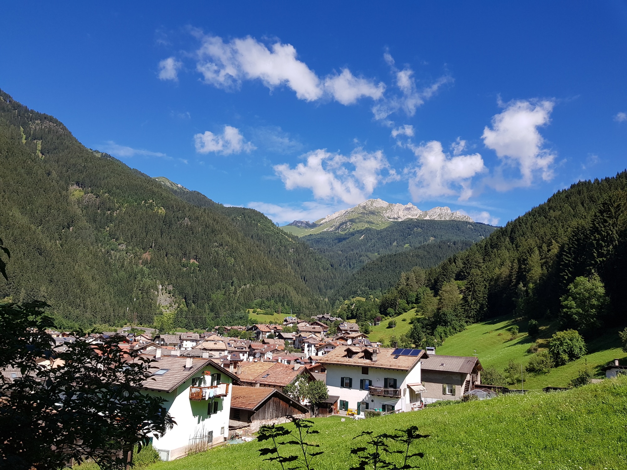 Villaggio montano sotto cielo azzurro con nuvole bianche