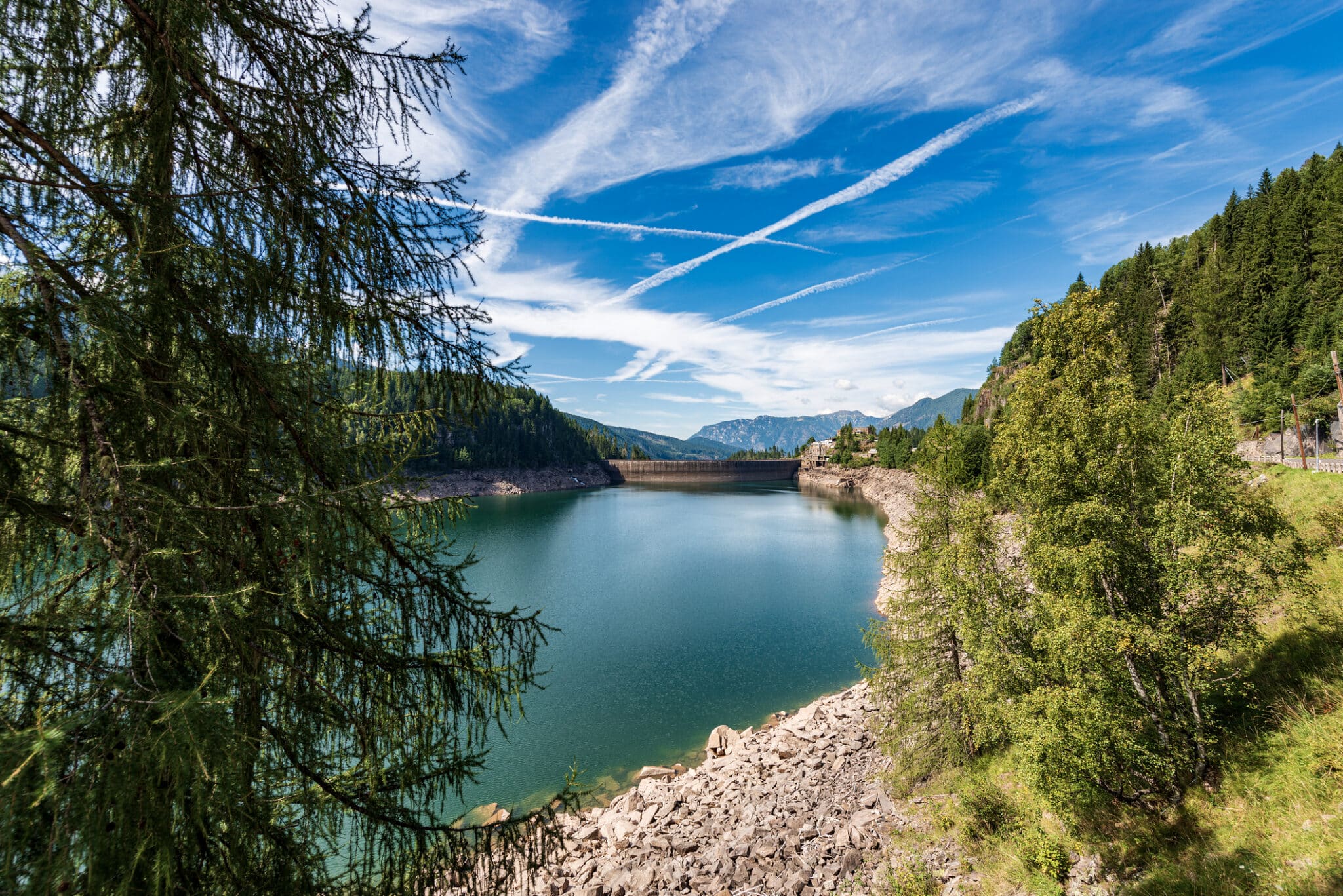 Lago di montagna circondato da foreste e cielo azzurro