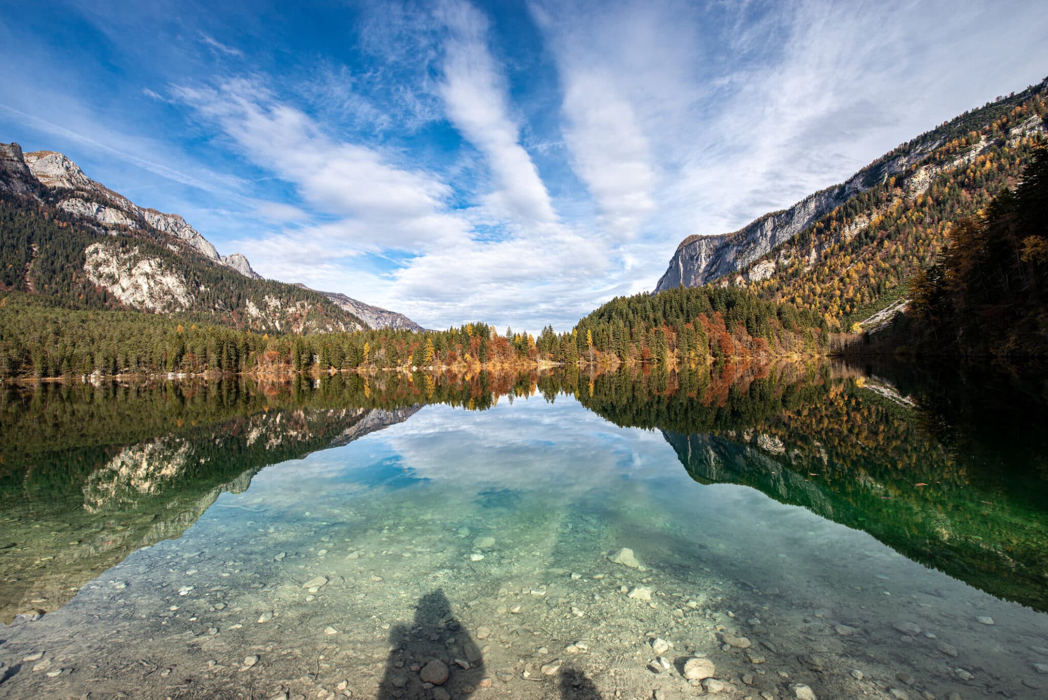 Lago montano autunnale con riflessi e cielo azzurro