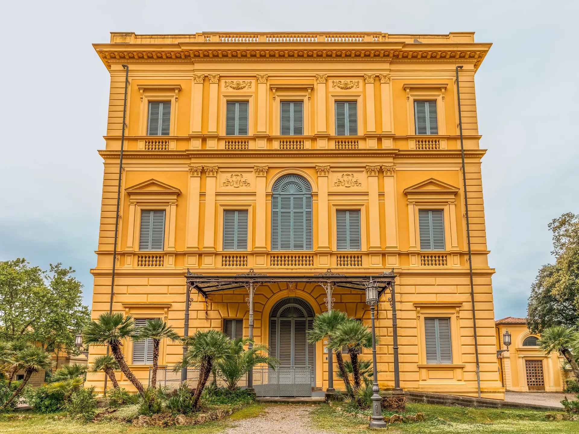 Villa gialla sontuosa con giardino e palme