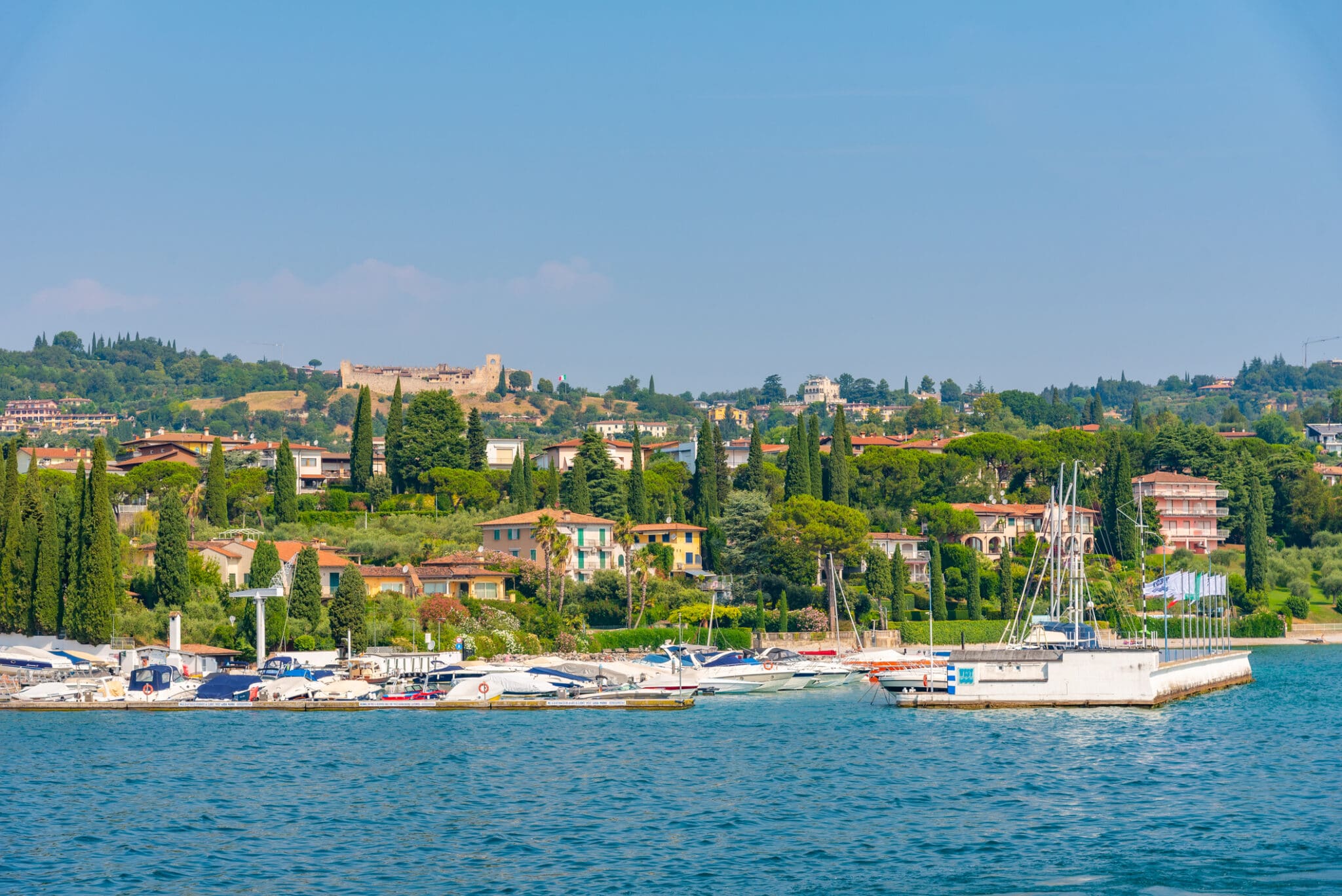 Panorama lago con barche e colline verdi