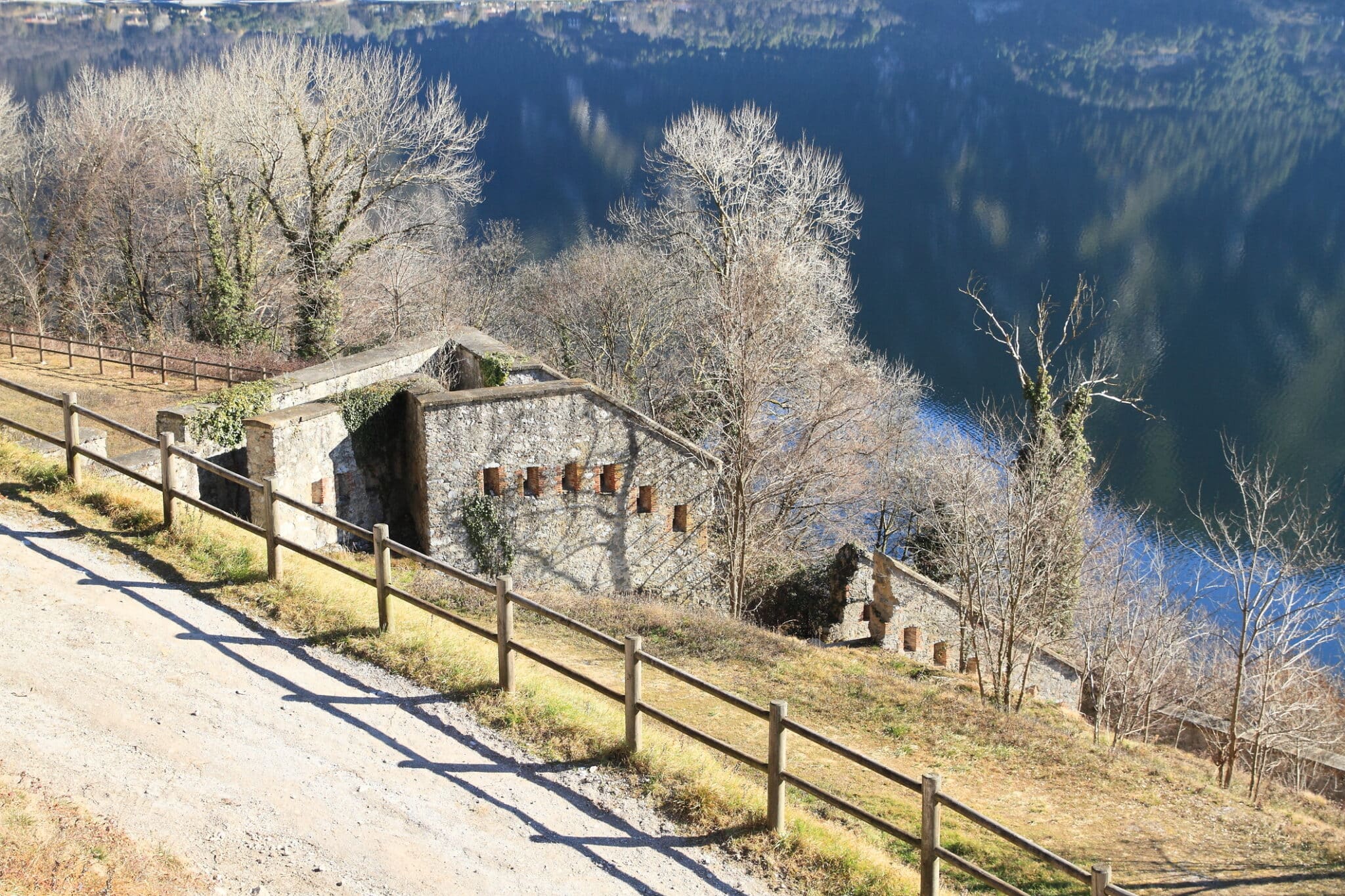 Sentiero invernale accanto a lago con edificio antico
