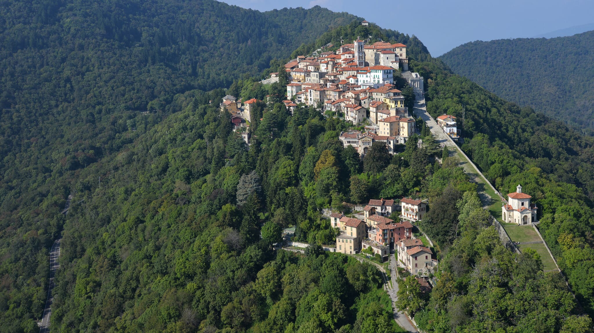 Villaggio collinare circondato da foreste verdi in Italia