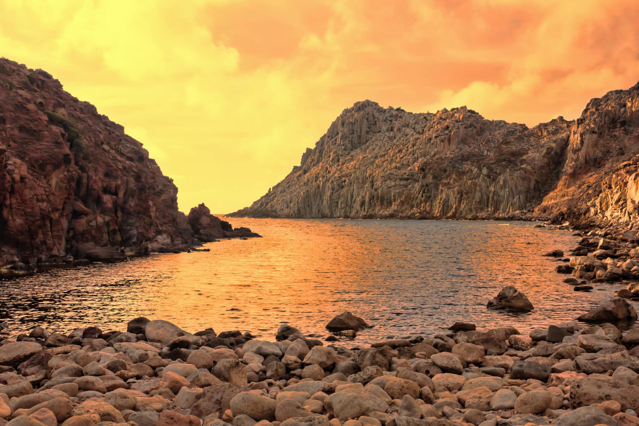 Tramonto rosa su scogliere e mare roccioso