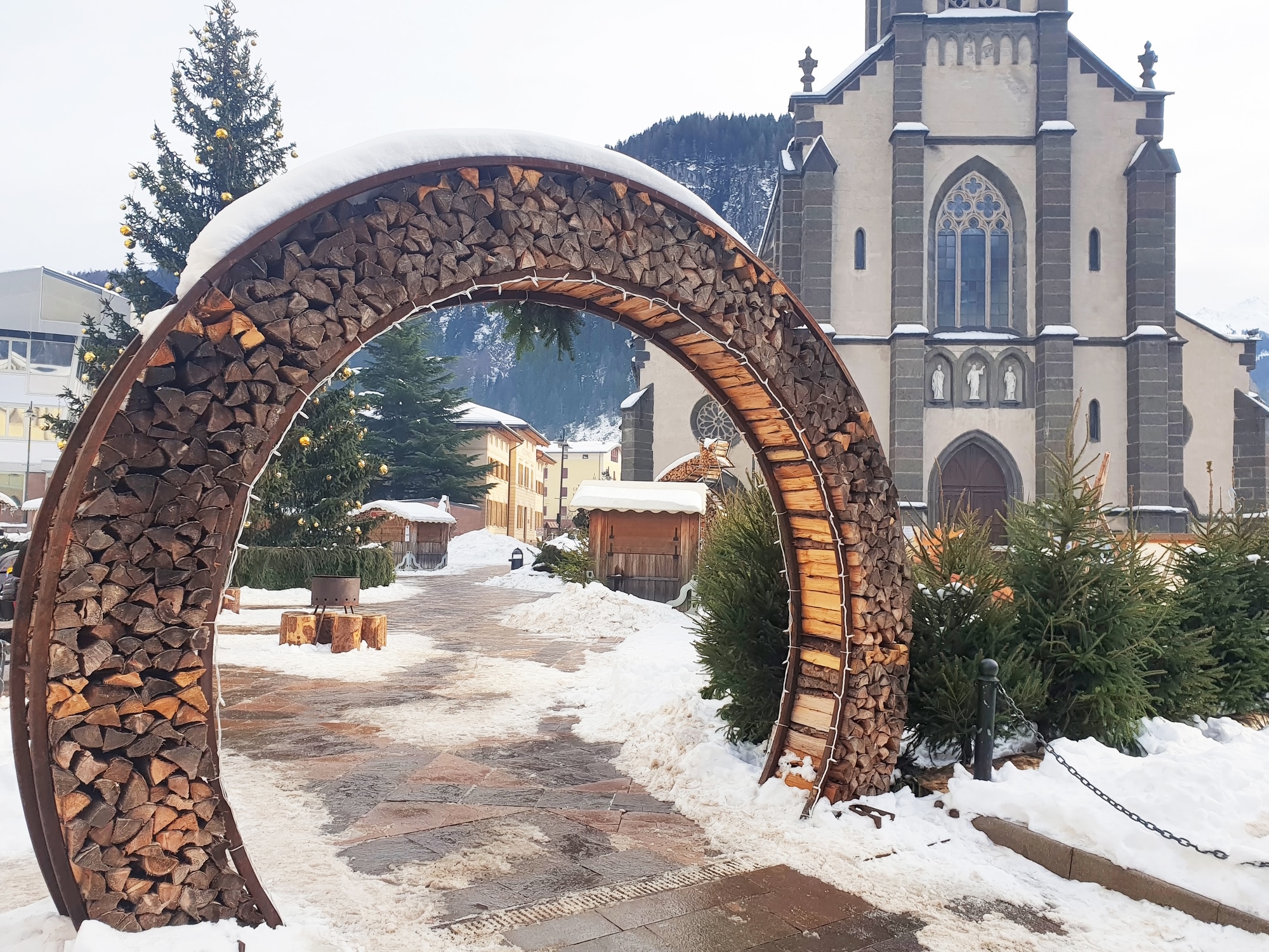Arco di legna innevato davanti a chiesa
