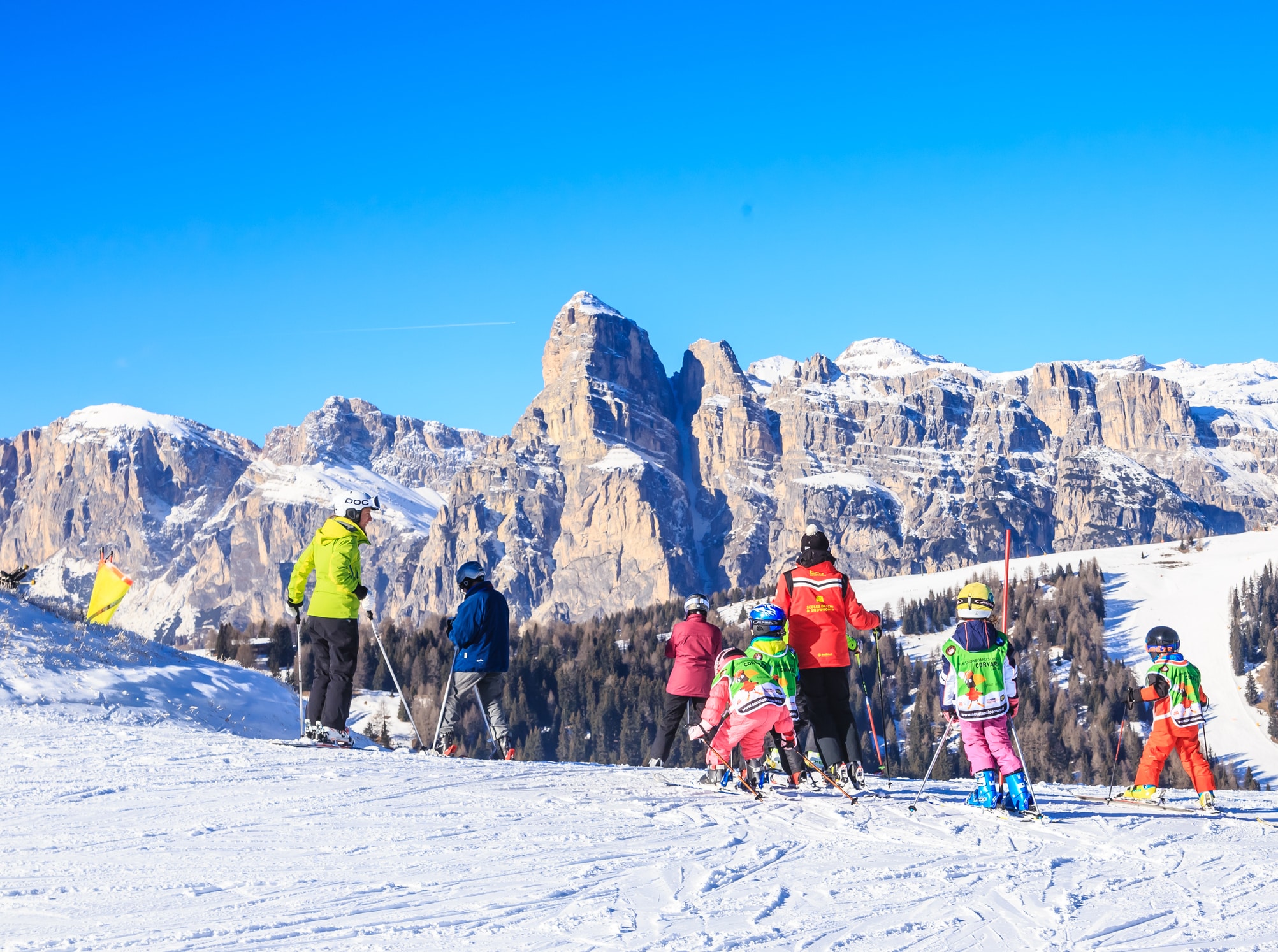 Sciatori su pista innevata con montagne