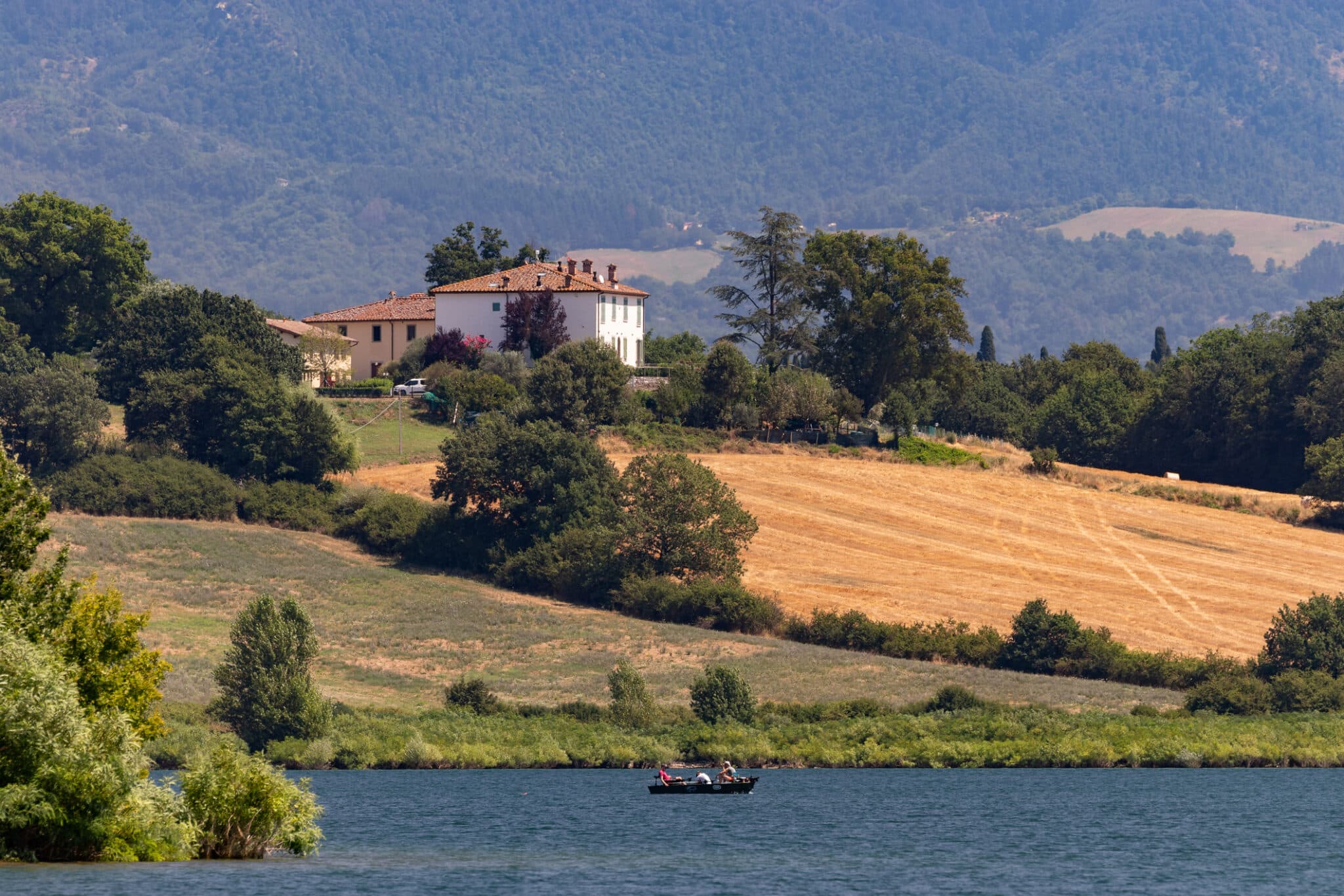 Casa rustica, lago, barca, montagne sfumate