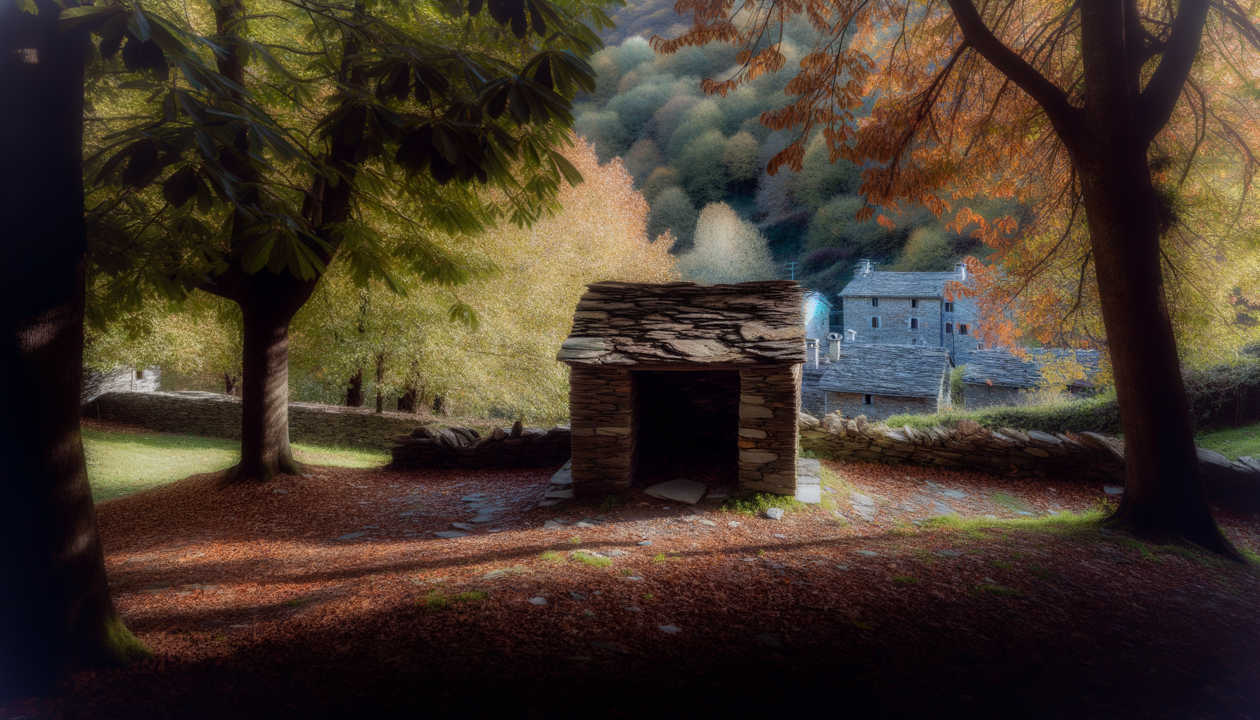 Piccolo edificio in pietra tra alberi di castagno con foglie autunnali nei colori caldi dell’Appennino